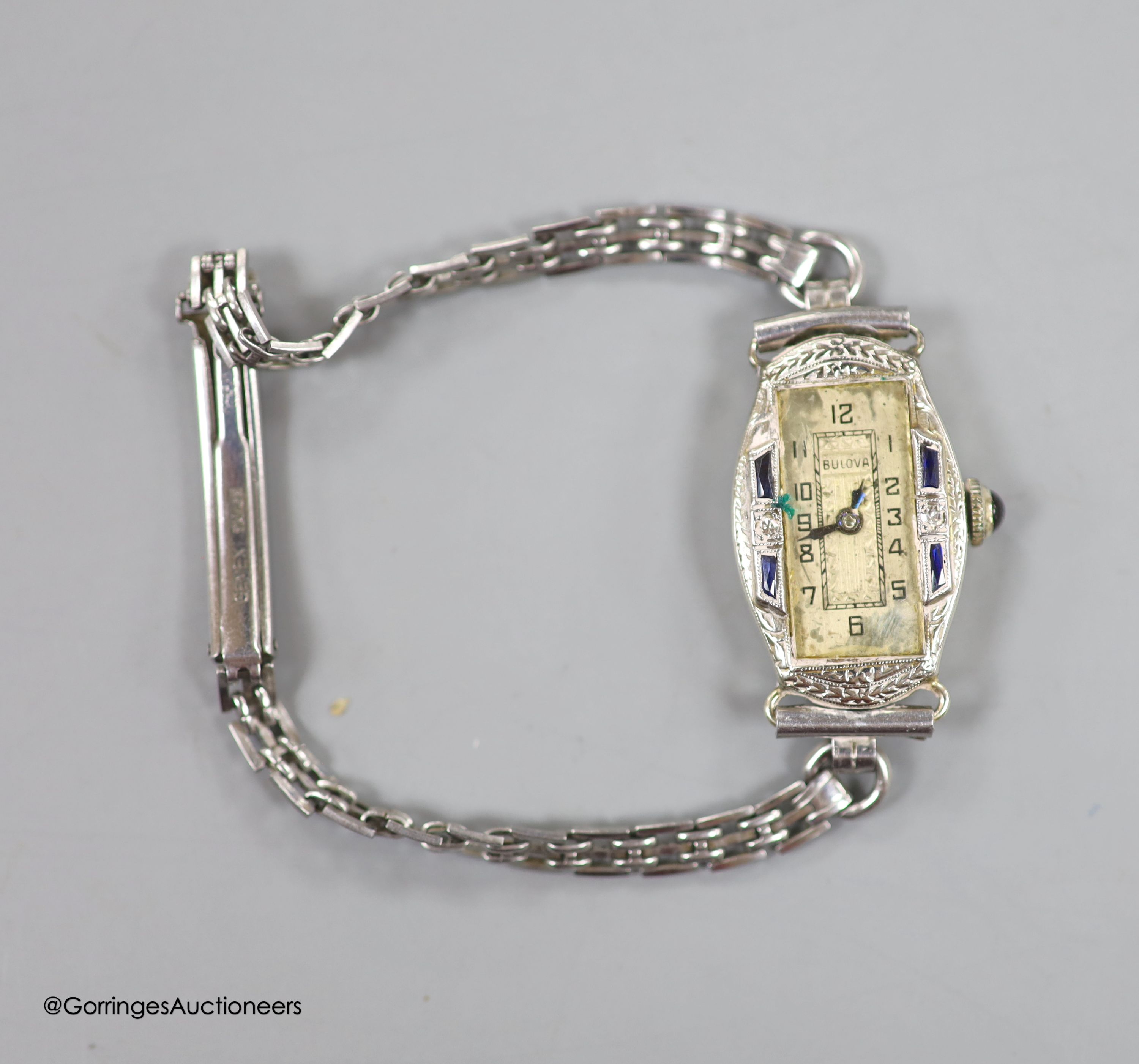 A lady's 1920's/1930's 18k white metal, synthetic sapphire? and diamond set Bulova manual wind cocktail watch, on a stainless steel bracelet.